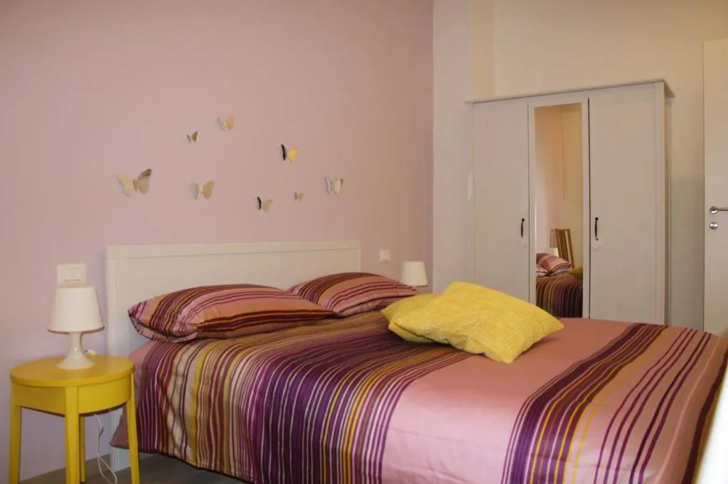 Camera matrimoniale rosa con decorazioni a farfalla